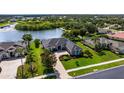 Aerial view of the home with a well-manicured front yard, situated near a scenic lake and lush greenery at 305 Lake Tahoe Ct, Englewood, FL 34223