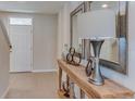 Inviting entryway with neutral tiles, a console table with decorative accents, and a view of the front door at 30823 Wild Juniper Ct, Brooksville, FL 34602