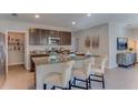 Modern kitchen with granite countertops, stainless steel appliances, island seating, and dark wood cabinets at 30823 Wild Juniper Ct, Brooksville, FL 34602