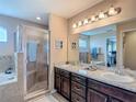 Spacious bathroom featuring double sinks, granite counters, and large framed mirror at 6812 Gideon Cir, Zephyrhills, FL 33541