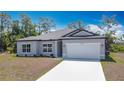 Inviting single-story home with a fresh driveway, landscaping, and attached garage at 3018 Oceanside St, North Port, FL 34286