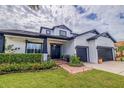 Beautiful front view of a two-story home with lush landscaping, a brick walkway, and a two-car garage at 205 Bengal Cir, Oldsmar, FL 34677