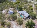 Aerial view showcasing the home with a screened-in pool and detached garage on a wooded lot at 10230 289Th E St, Myakka City, FL 34251