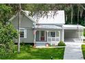 Charming home with covered porch, American flag and a spacious carport for parking at 304 Highland St, Brooksville, FL 34601