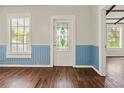 The inviting living area features gleaming hardwood floors and a decorative stained-glass front door at 304 Highland St, Brooksville, FL 34601