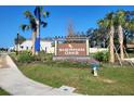 Sherman Oaks community sign, featuring lush landscaping and palm trees in a well-maintained neighborhood at 30846 Wild Juniper Ct, Brooksville, FL 34602