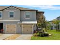 Charming townhome showcasing gray exterior, front yard, and two-car attached garages at 14347 Easy Goer St, Ruskin, FL 33573