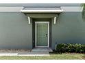 Inviting front entry showcasing a green door, gray siding, and a covered porch at 14347 Easy Goer St, Ruskin, FL 33573