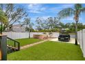 The backyard has artificial grass, modern lounge furniture, privacy fence and lush tropical landscaping at 2715 14Th N Ave, St Petersburg, FL 33713