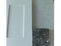 Close-up showcases a clean white cabinet door paired with a sample of speckled black granite for a stylish interior at 5461 Ocean Breeze Dr, Spring Hill, FL 34609