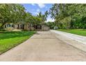 Spacious driveway leading to a cozy home with mature trees and attached garage at 39 Sunset Dr, Brooksville, FL 34601