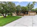 Well-maintained home featuring a tidy lawn, mature trees and an attached garage at 39 Sunset Dr, Brooksville, FL 34601
