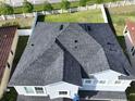 Aerial view of a roof with dark shingles surrounded by a white fence and greenery at 11928 Frost Aster Dr, Riverview, FL 33579
