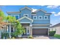 Two-story house with gray exterior, brown garage door, and lush landscaping at 11928 Frost Aster Dr, Riverview, FL 33579