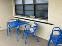 Inviting outdoor patio area with a vibrant blue metal table and chairs at 24 Quails Run Blvd # 3, Englewood, FL 34223