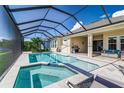 Resort-style pool and spa with covered lanai, outdoor kitchen, and lake view at 5330 Silver Sun Dr, Apollo Beach, FL 33572