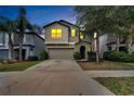 Two story house exterior at dusk with a two-car garage at 12730 Lemon Pepper Dr, Riverview, FL 33578