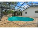 Inviting kidney-shaped pool with covered patio and spa at 2892 North Rd, Clearwater, FL 33760