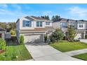 Two-story house with a neutral color scheme, a two-car garage, and a well-manicured lawn at 10662 Hawks Landing Dr, Land O Lakes, FL 34638