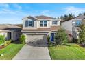 Two-story house with a neutral color scheme, a two-car garage, and a landscaped yard at 10662 Hawks Landing Dr, Land O Lakes, FL 34638