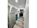 Modern kitchen with white cabinets, teal dishwasher, and stainless steel appliances at 7108 Waterside Dr # 103, Tampa, FL 33617