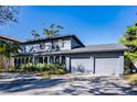 Two-story house with gray siding, landscaped yard, and a two-car garage at 4911 W Juno St, Tampa, FL 33629