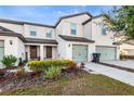 Townhome featuring a well-manicured lawn, colorful landscaping, and a stylish front entrance at 5327 New Friendship Pl, Tampa, FL 33619