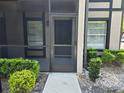 Screened entryway with neutral colors, landscaping, and a storm door for added security at 14663 Norwood Oaks Dr # 103, Tampa, FL 33613