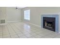 Living room featuring tile flooring, a window, and a fireplace with blue tile surround at 14663 Norwood Oaks Dr # 103, Tampa, FL 33613