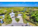 Gorgeous riverfront home with lush landscaping, a private dock, and long driveway at 283 Hilltop Cir, Punta Gorda, FL 33982