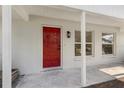 Inviting front porch with a striking red door and updated lighting fixtures at 1103 W Dixie St, Plant City, FL 33563