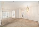 Spacious living room featuring neutral walls, carpeted floor, chandelier and arched doorways at 11924 Northumberland Dr, Tampa, FL 33626