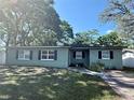 Inviting single-story home with a well-manicured lawn, traditional windows, and mature trees providing shade at 1808 Heather Ave, Tampa, FL 33612