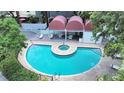 Inviting community pool and spa area with lounge seating, covered cabanas, and meticulously landscaped surroundings at 3211 W Swann Ave # 911, Tampa, FL 33609