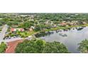 Beautiful aerial view of a lakeside community, showcasing homes with orange roofs surrounded by mature trees at 6621 La Mesa Rd, Land O Lakes, FL 34637