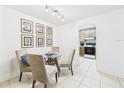 Dining room with a glass table, four chairs and decorative wall art at 2700 Bayshore Blvd # 3210, Dunedin, FL 34698