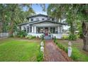 Two-story home with inviting front porch, red door, and well-manicured landscaping at 1007 N Wheeler St, Plant City, FL 33563