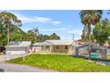 Charming home with metal roof, screened pool, and covered porch, set on a green lawn at 3620 E Tampa Cir, Tampa, FL 33629