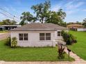 Charming white home featuring a well-maintained lawn and cozy front entrance at 602 E Laura St, Plant City, FL 33563