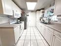 Bright white kitchen features updated cabinets, countertop, tiled floor and stainless steel appliances at 7943 Woodvine Cir, Tampa, FL 33615