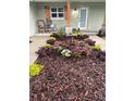 Up close image of the front yard landscaping with river rock, seasonal flowers, and wooden shutters flanking a window at 106 Corbett Rd, Lithia, FL 33547