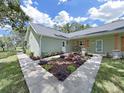 Front exterior showcases concrete walkway and lovely landscaping with various flowering plants at the front of the house at 106 Corbett Rd, Lithia, FL 33547
