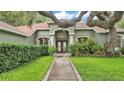 Charming home exterior with lush landscaping, a welcoming entryway, and a well-maintained lawn at 2332 Timbergrove Dr, Valrico, FL 33596