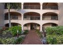 Charming condo entrance with brick path, lush landscaping, and covered walkways to units at 23465 Harborview Rd # 223, Punta Gorda, FL 33980