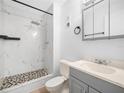 Bathroom featuring tiled shower with glass door and updated vanity at 3811 N Oak Dr # E62, Tampa, FL 33611