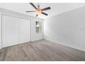 This bedroom features wood-look floors, a ceiling fan and a double closet at 3811 N Oak Dr # E62, Tampa, FL 33611