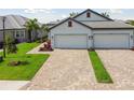 Two-car garage with paver driveway and landscaping at 17810 Cherished Loop, Bradenton, FL 34211