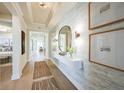 Bright hallway with elegant lighting, decorative mirror, wall art, and views into other rooms at 1500 Lugano Cir, Nokomis, FL 34275