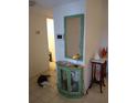Bright entryway with a green cabinet, mirror, and a comfortable cat at 1608 Bob O Link Dr, Venice, FL 34293