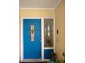 Inviting blue front door accented with a 'Welcome Home' sign and wreath at 1608 Bob O Link Dr, Venice, FL 34293